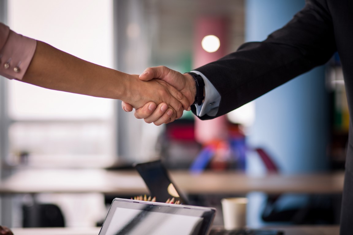 Business partners handshaking. Close up view of woman and man shaking hands.